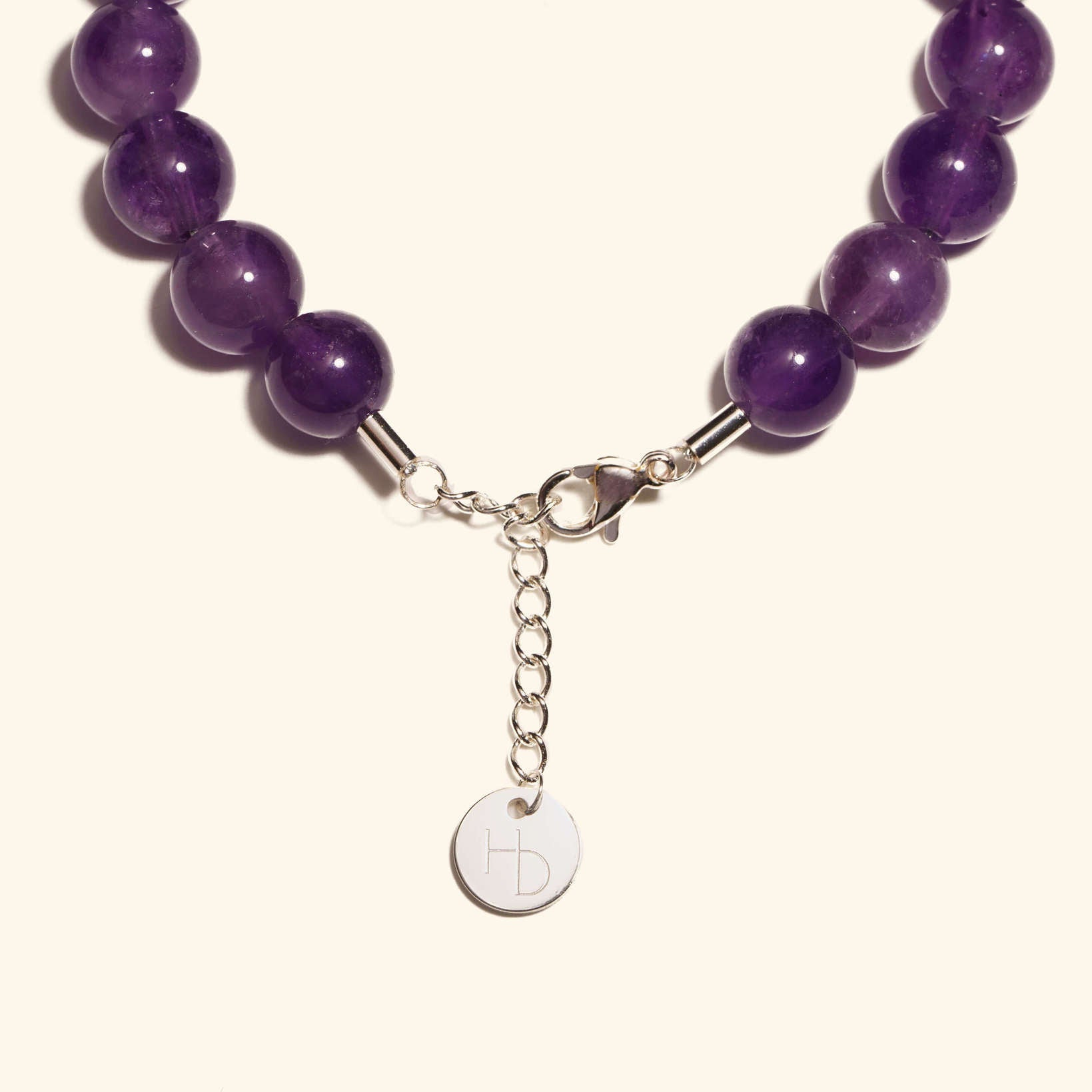 Amethyst silver charm bracelet close up showing the adjustable length extender and clasp