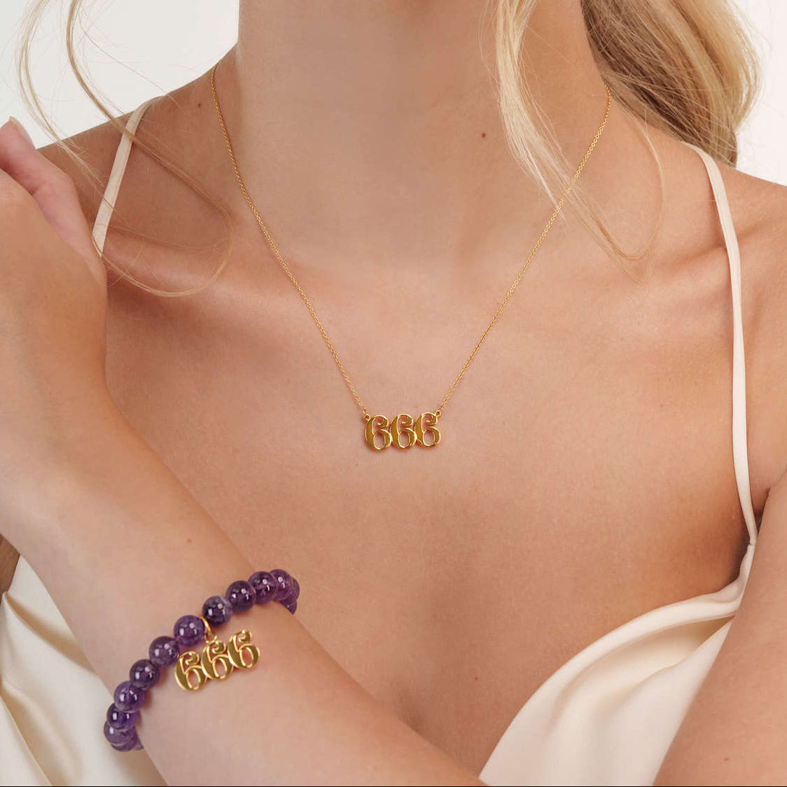 Model wearing a 666 gold bracelet with a matching 666 gold necklace