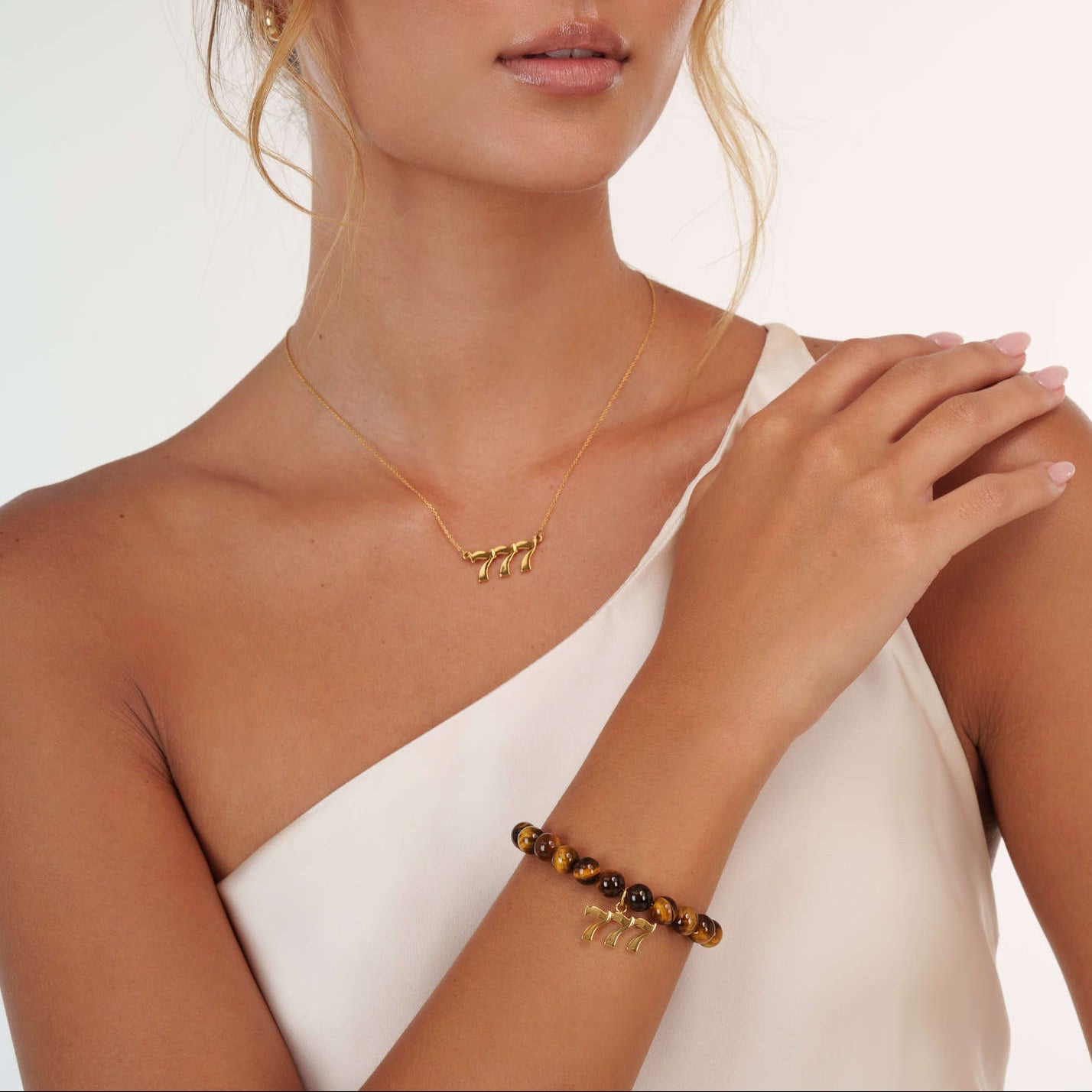 Model wearing an Tigers Eye 777 Gold bracelet with a matching 777 Gold necklace
