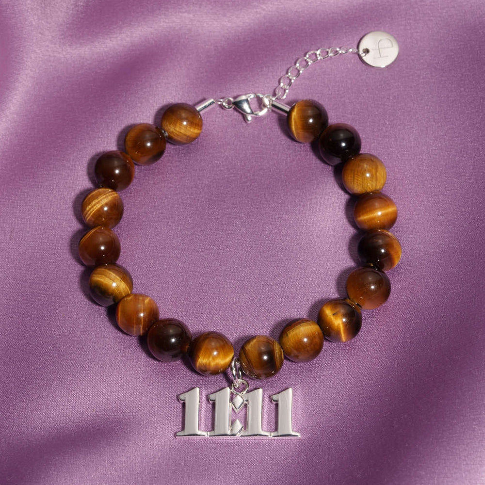 11:11 Silver charm on beaded Tigers Eye bracelet laying on silk
