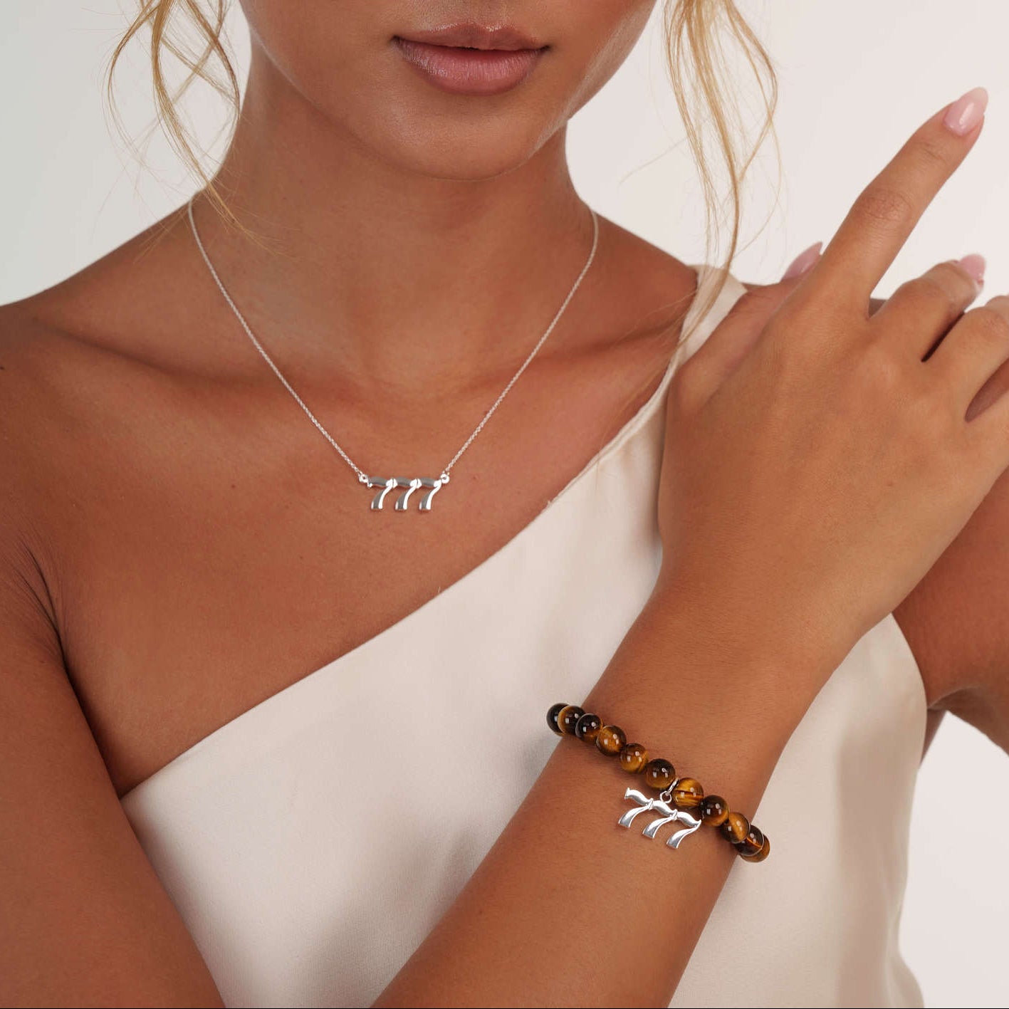 Model wearing an Tigers Eye 777 Silver bracelet with a matching 777 Silver necklace
