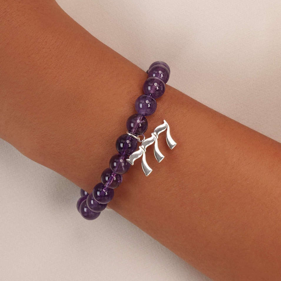 High quality purple amethyst beads with dangling 777 Silver charm on wrist
