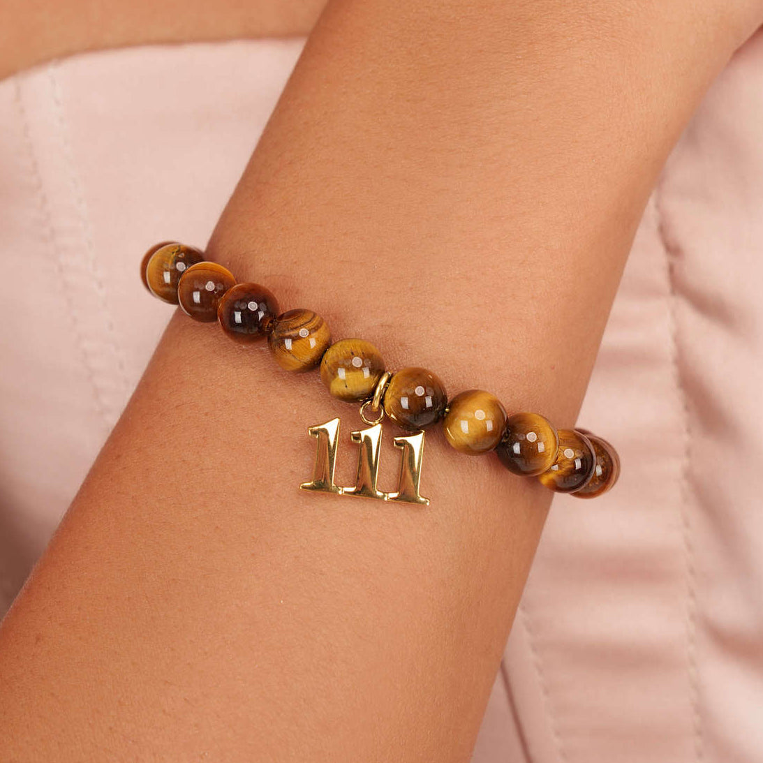 High quality Tigers Eye beads with dangling 111 Gold charm on wrist
