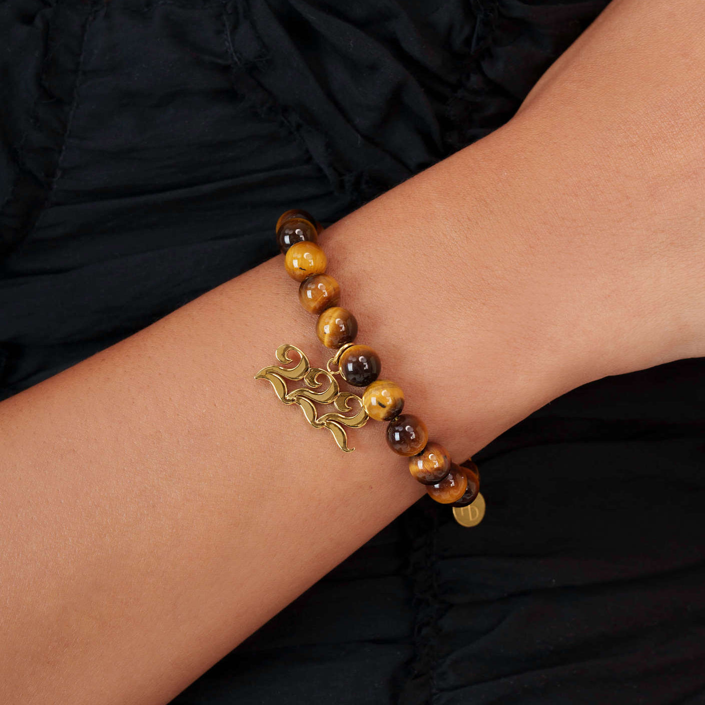 High quality Tigers Eye beads with dangling 222 Gold charm on wrist
