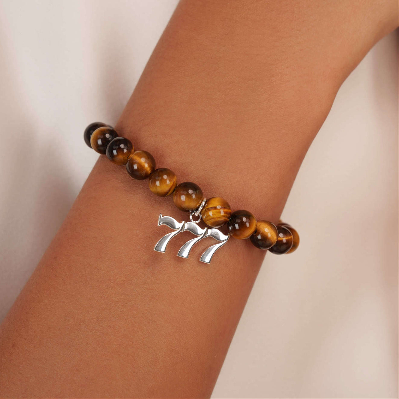 High quality Tigers Eye beads with dangling 777 Silver charm on wrist
