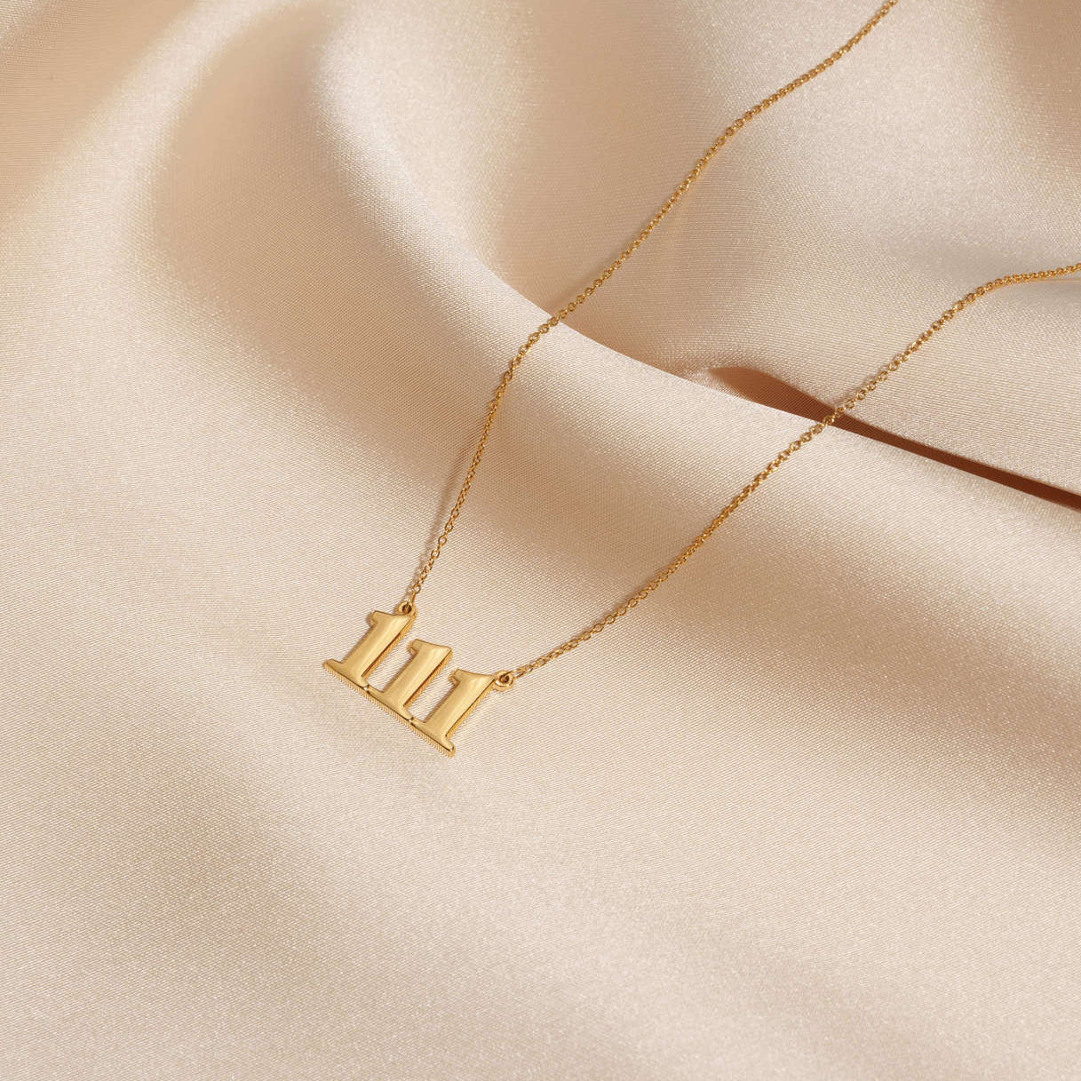111 gold necklace on silk
